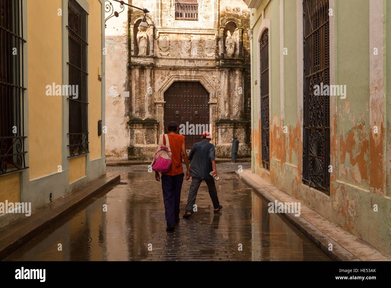 Due cubani navigazione intorno a una strada allagata dopo una pioggia pesante nella Vecchia Havana, Cuba. Foto Stock