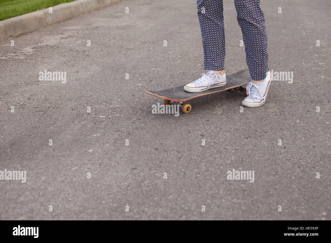 La donna lo skateboard su strada Foto Stock