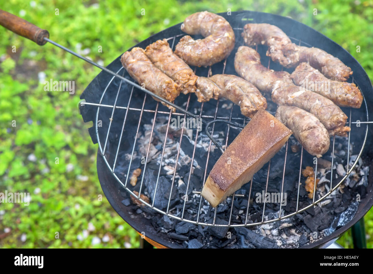 Salsicce e lardo su un grill Foto Stock