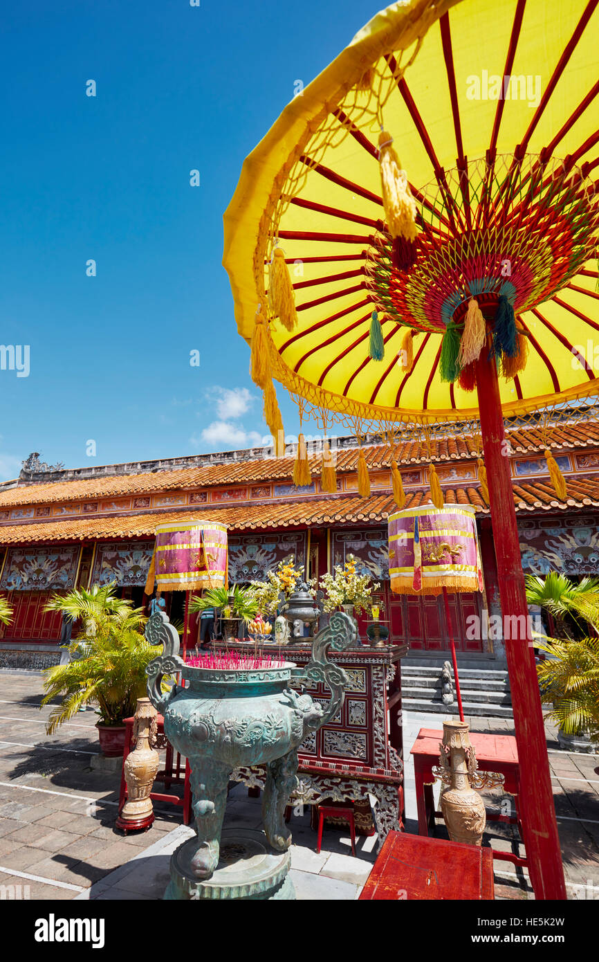 Altare di bronzo incenso urn e ombrellone giallo al Mieu al tempio. Città Imperiale (Cittadella), tonalità, Vietnam. Foto Stock