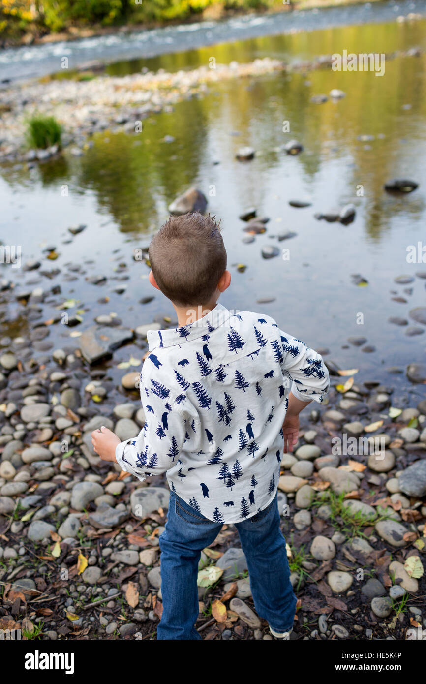 I fratelli gettare pietre nel fiume McKenzie insieme nel colpo di stile di vita dei bambini che si divertono a giocare. Foto Stock