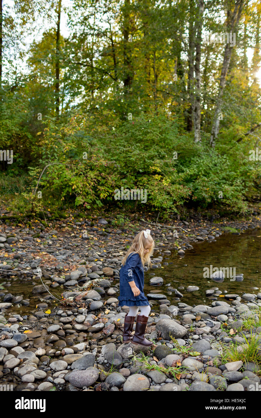 Bambina esplorando il fiume McKenzie con rocce e acqua nei pressi di Eugene, Oregon. Foto Stock