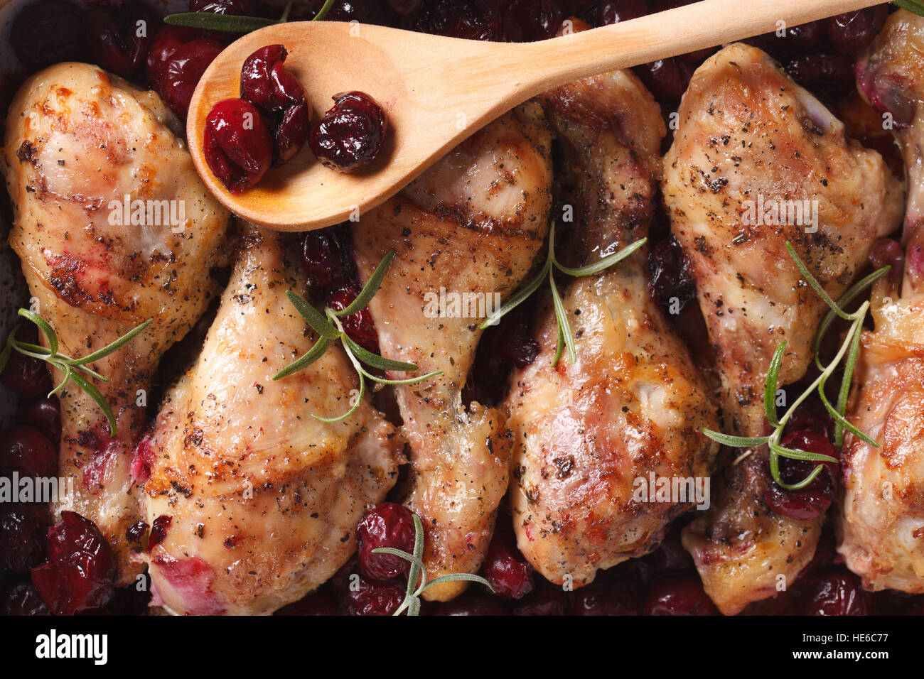 Pollo al Forno con gamba ciliegia e rosmarino macro. Orizzontale vista superiore Foto Stock