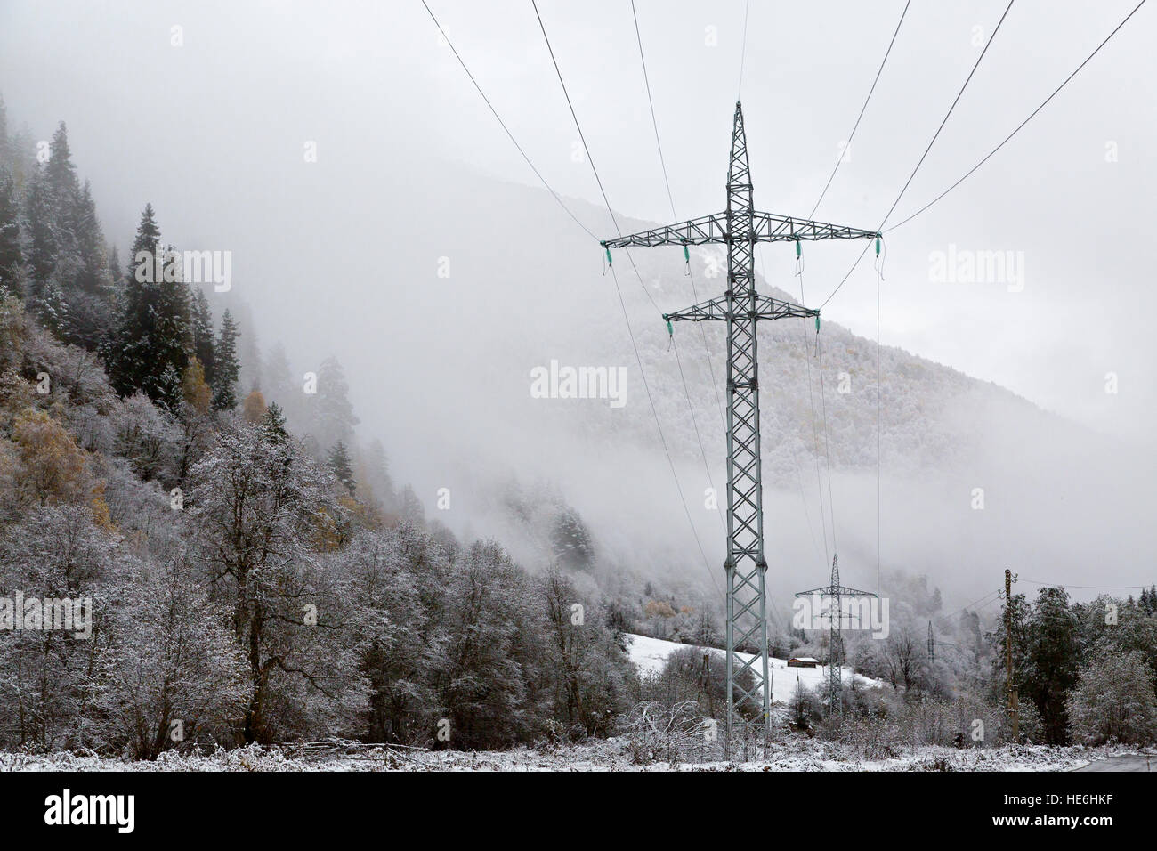 Linee elettriche in una giornata di nebbie e neve nelle montagne del Caucaso, Georgia Foto Stock