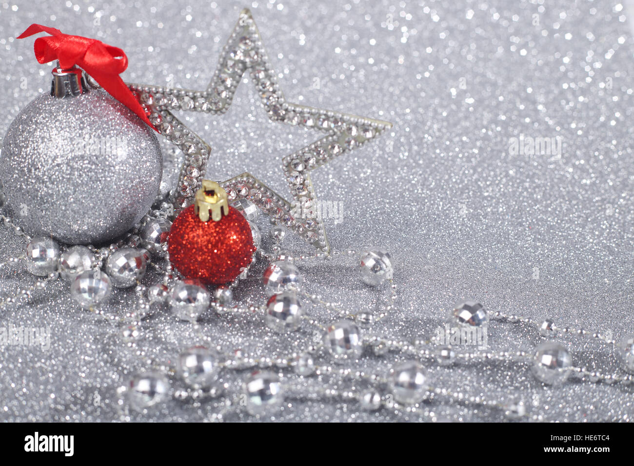 Decorazioni di Natale su shiny glitter con fondo argento con spazio di copia Foto Stock