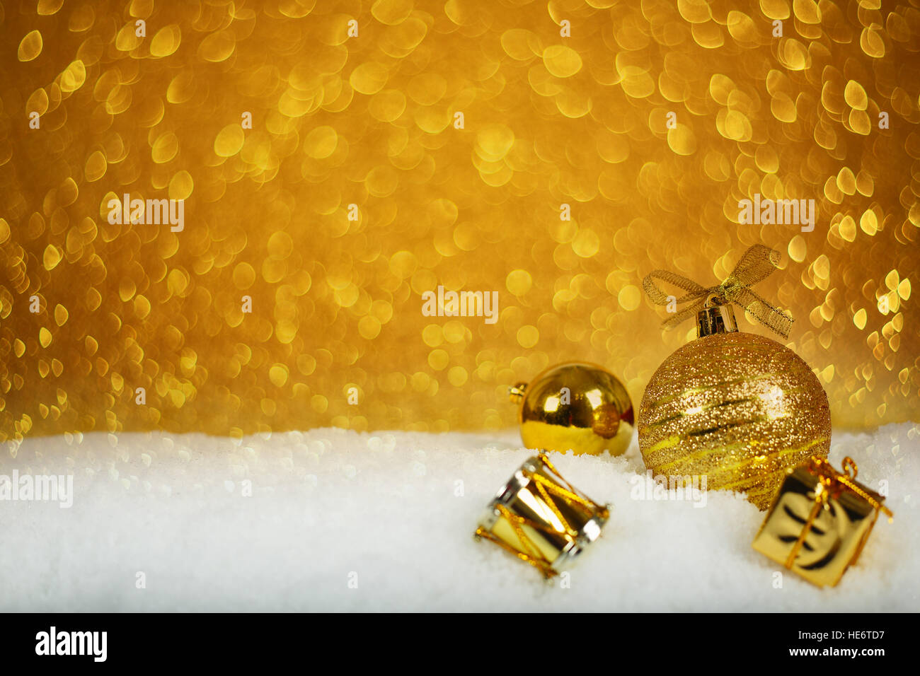 Golden decorazioni di Natale nella neve su sfondo glitter Foto Stock