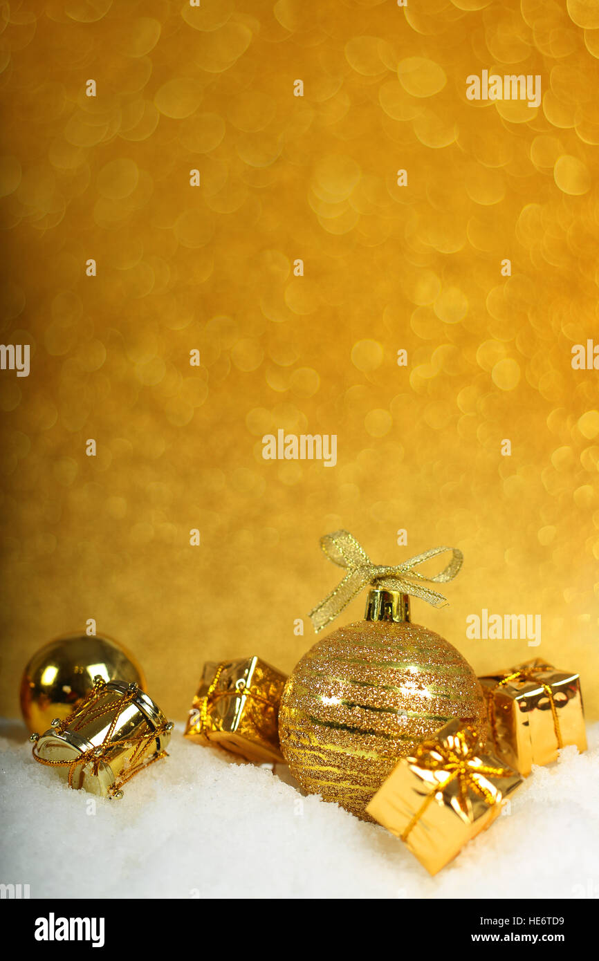 Golden decorazioni di Natale nella neve su sfondo glitter Foto Stock
