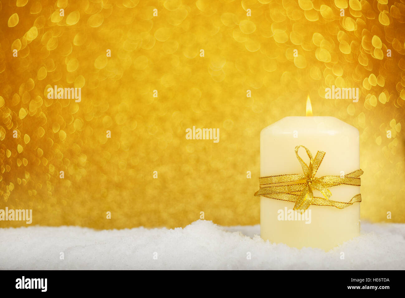 Christmas candle con golden decorazioni di Natale nella neve su sfondo glitter Foto Stock