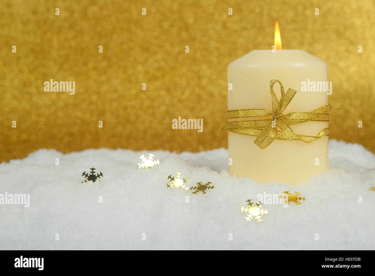 Christmas candle con golden decorazioni di Natale nella neve su sfondo glitter Foto Stock
