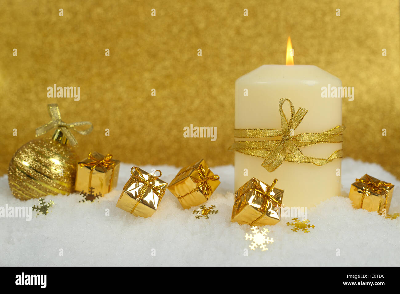 Christmas candle con golden decorazioni di Natale nella neve su sfondo glitter Foto Stock