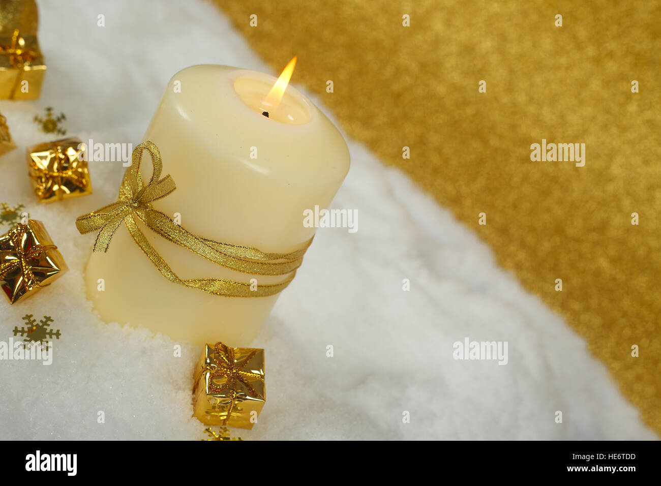 Christmas candle con golden decorazioni di Natale nella neve su sfondo glitter Foto Stock