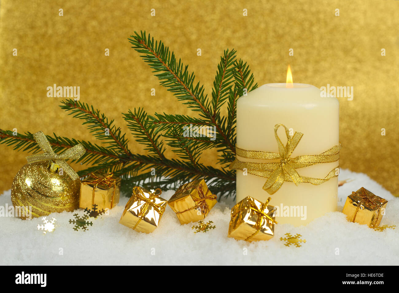 Christmas candle con golden decorazioni di Natale nella neve su sfondo glitter Foto Stock