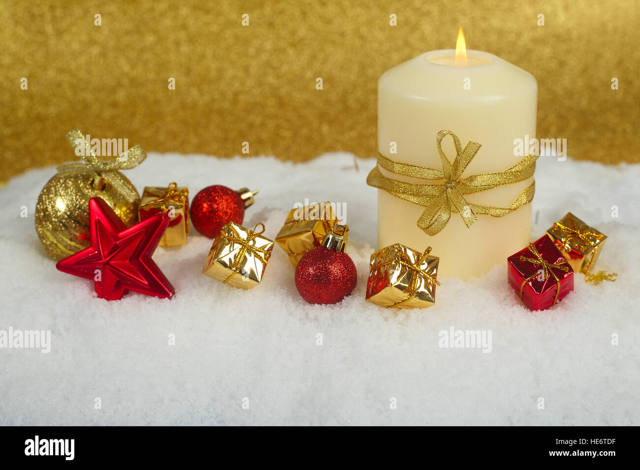Christmas candle con golden decorazioni di Natale nella neve su sfondo glitter Foto Stock