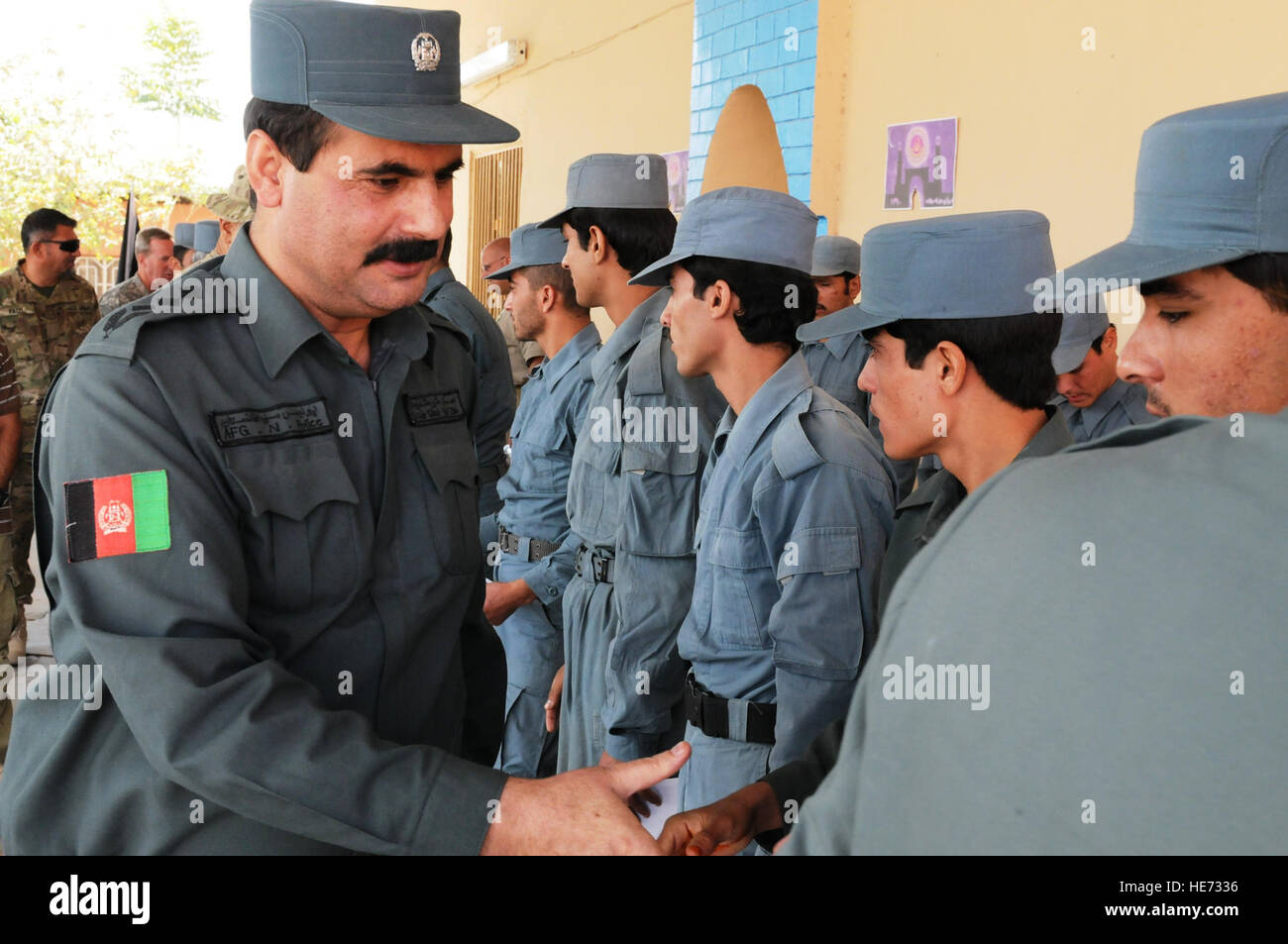 Polizia nazionale afgana Col. Shir Shan (sinistra), si congratula con i laureati dell'Anp le indagini penali in corso presso il Camp Nathan Smith, Sett. 28, a Kandahar, Afghanistan. Gli studenti ha studiato le tecniche di colloquio, di base indagine penale, forensics, ordigni esplosivi artigianali, la sensibilizzazione al problema delle mine di base e le procedure mediche. Foto Stock