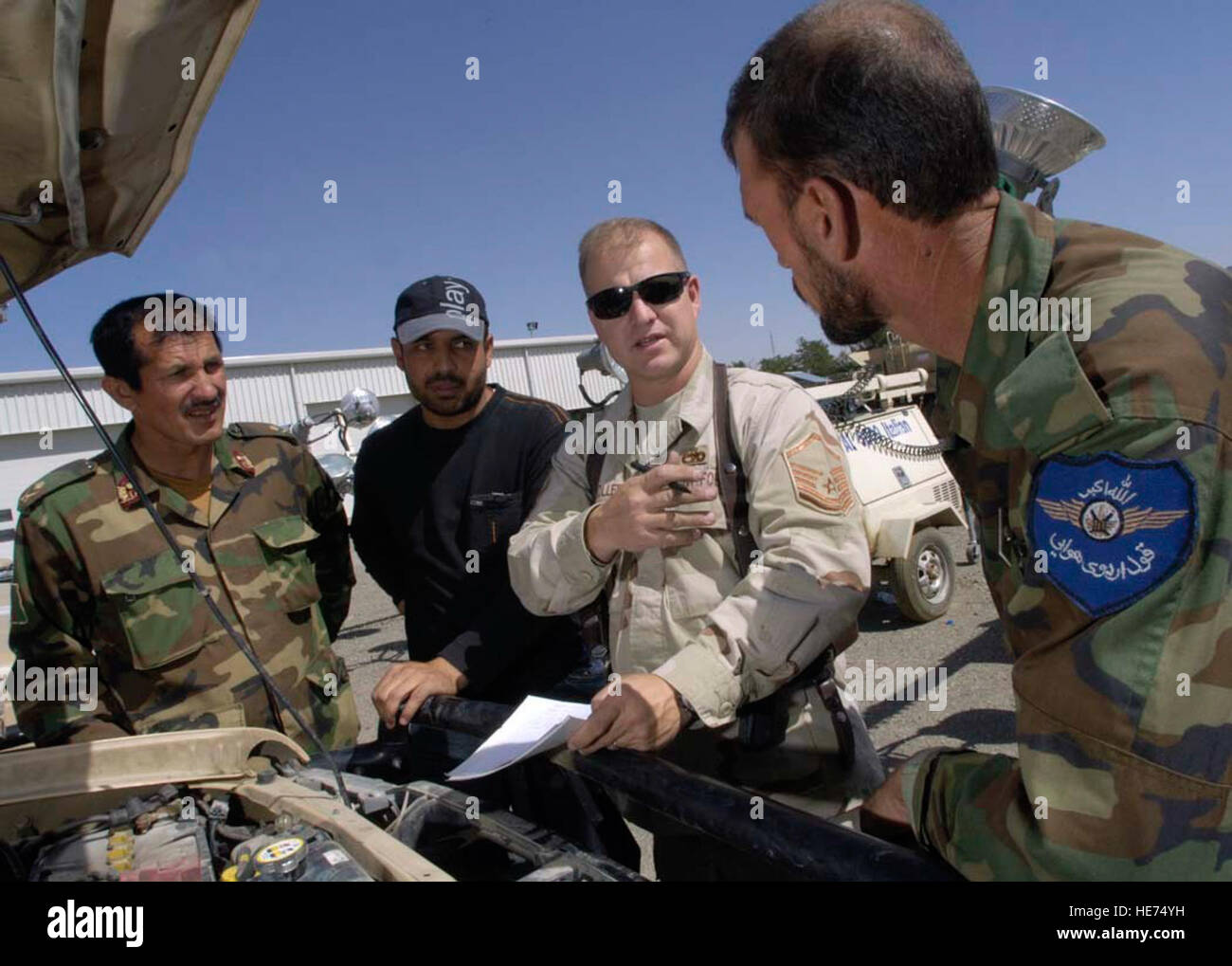 Stati Uniti Air Force mentor Master Sgt. Michael Stoller (secondo da destra) funziona con i membri dell'esercito nazionale afghano air corps, il 25 luglio a Kabul International Airport (KIA) Afghanistan. Stoller è un veicolo artigiano di manutenzione ed è distribuito da Eielson Air Force Base in Alaska. Stoller è assegnato al combinato per la sicurezza nella fase di transizione (Command-Afghanistan CSTC-A) che ha sede a Camp Eggers, Kabul, Afghanistan. CSTC-un partner con il governo della Repubblica islamica dell'Afghanistan e la comunità internazionale, per pianificare, programmare e implementare strutturali, organizzativo, in Foto Stock