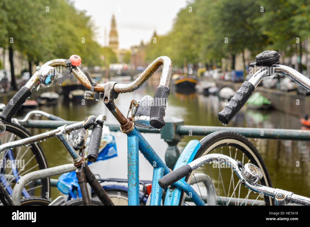 Bicicletta parcheggiata su un ponte nel centro della cittã di Amsterdam in un giorno nuvoloso Foto Stock