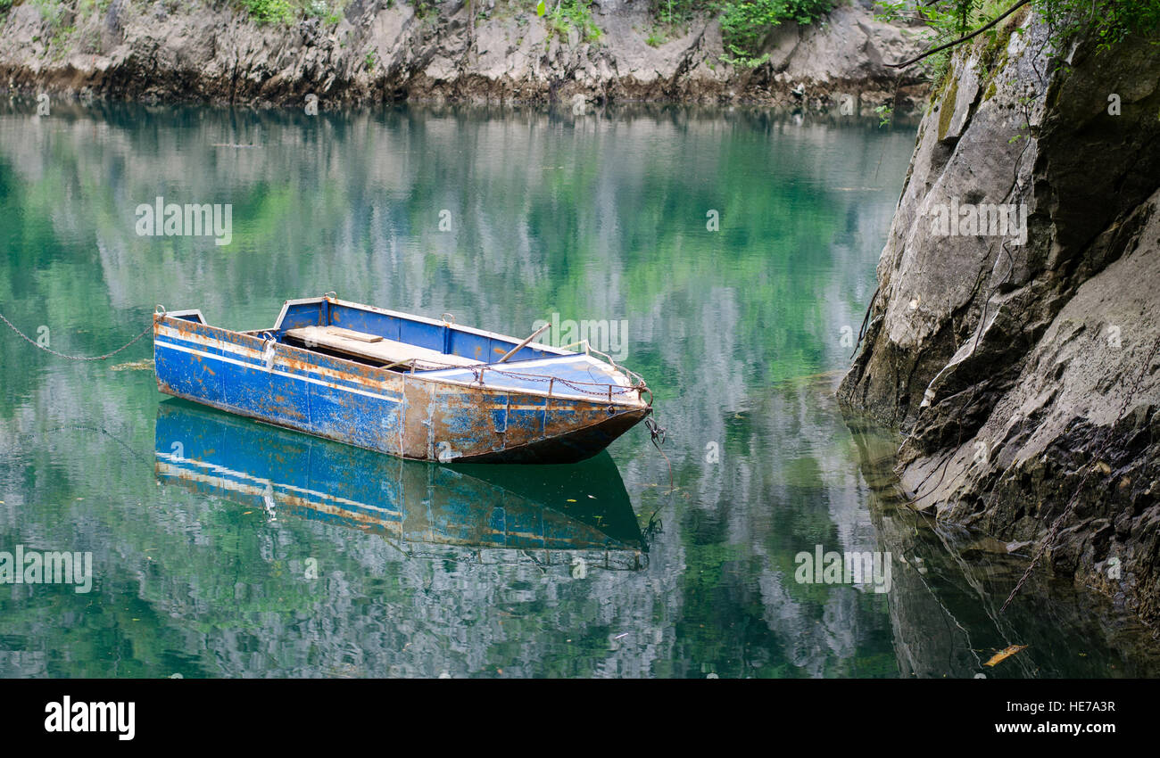 Barca galleggiante sulla calma di color verde acqua di lago Foto Stock