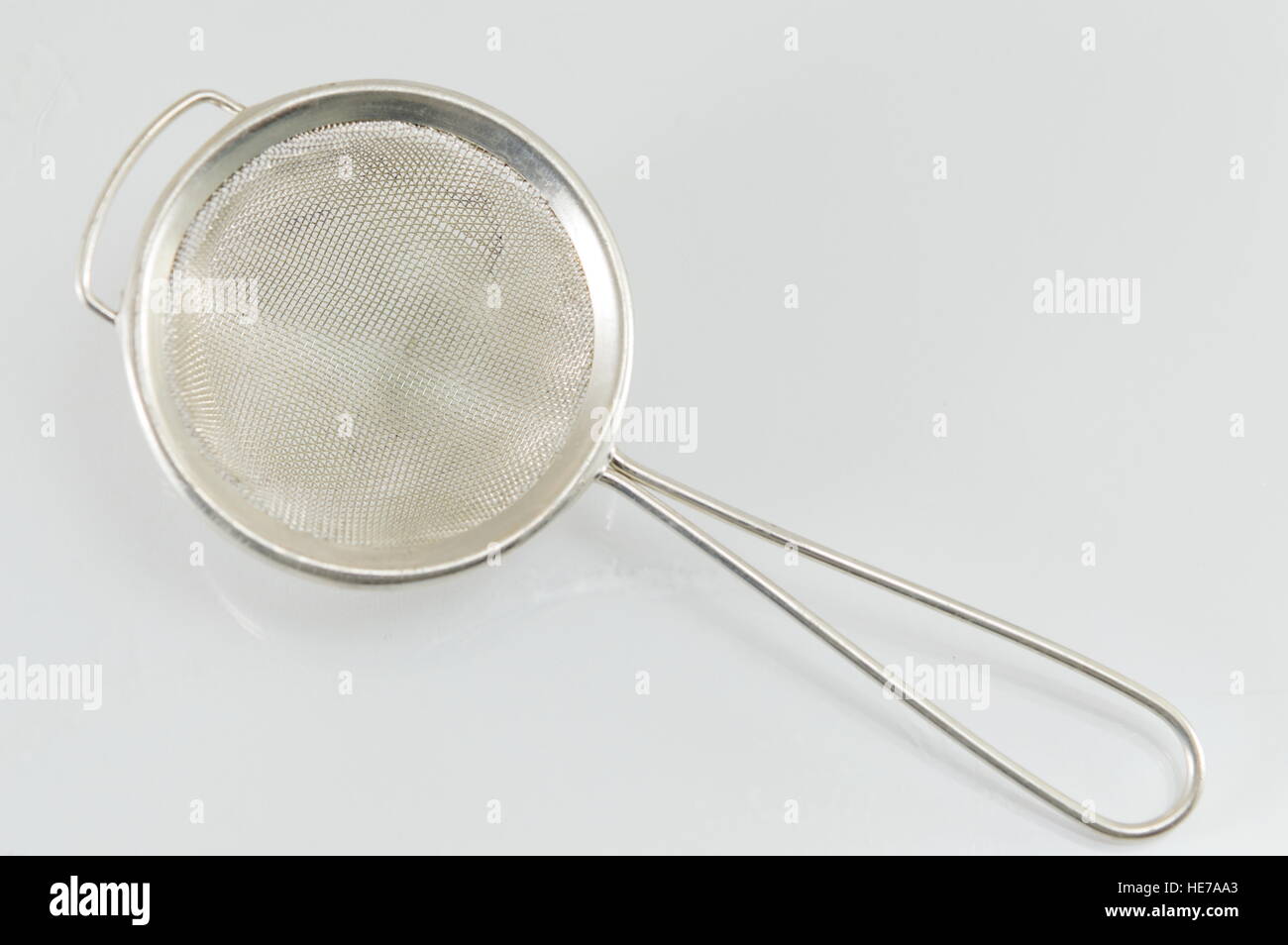 Palmare scolapasta utensile riflettente su sfondo bianco Foto Stock