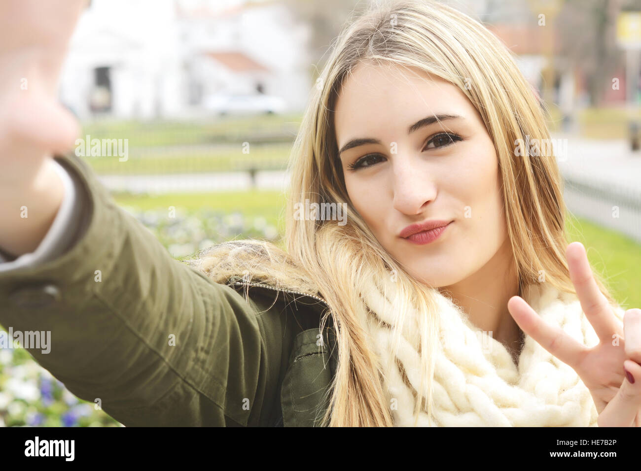 Ritratto di una giovane donna bellissima tenendo selfie. All'esterno. Foto Stock