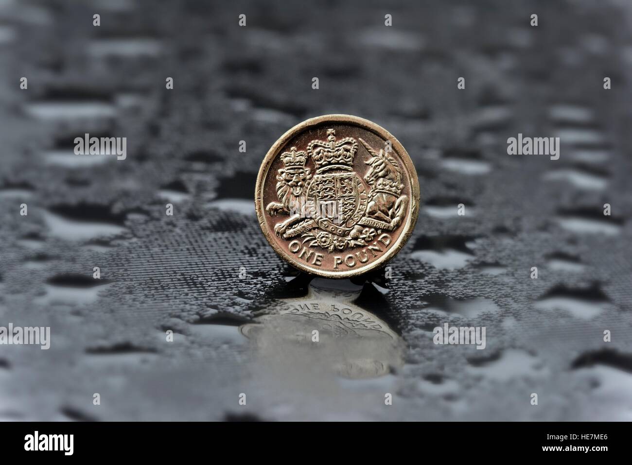 Una sterlina moneta su una tabella con le goccioline di acqua Foto Stock