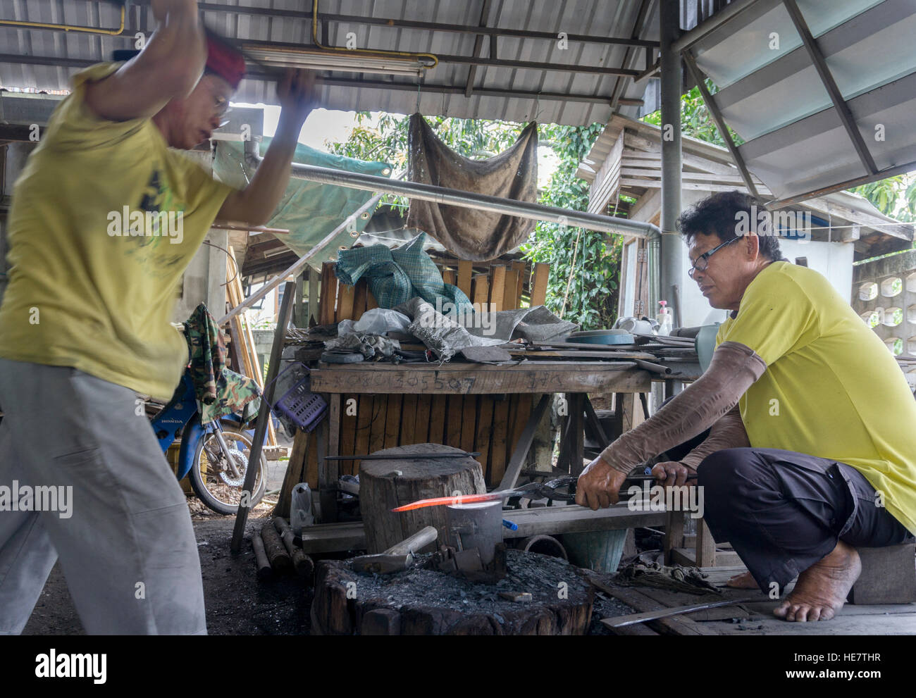 I produttori di spada tradizionali - fabbri / bladesmith che fanno una spada tradizionale a una fucina a Lampang, Thailandia, Asia Foto Stock