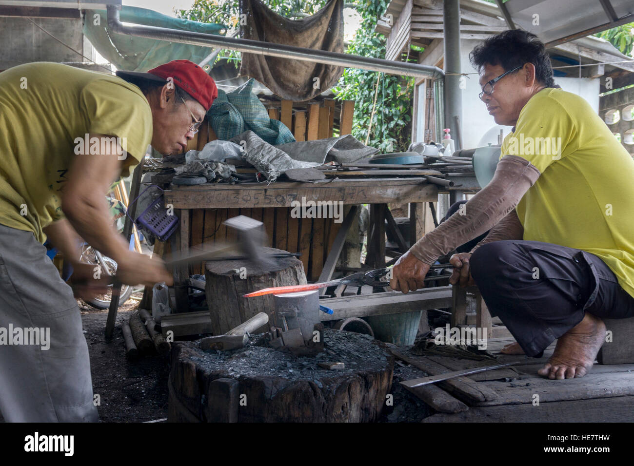 I produttori di spada tradizionali - fabbri / bladesmith che fanno una spada tradizionale a una fucina a Lampang, Thailandia, Asia Foto Stock