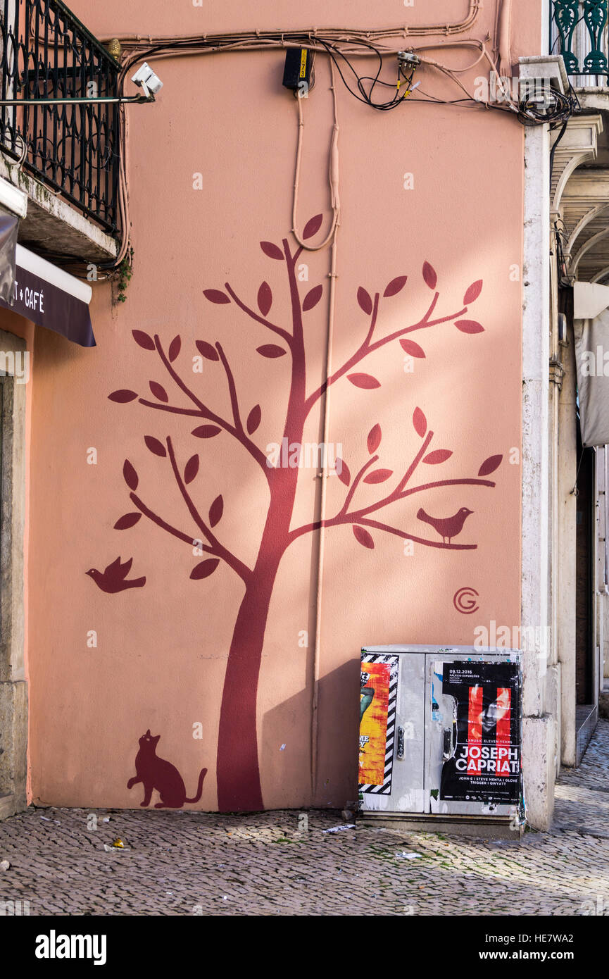 Street murale di un gatto guardando un uccello in un albero, Lisbona Portogallo Foto Stock