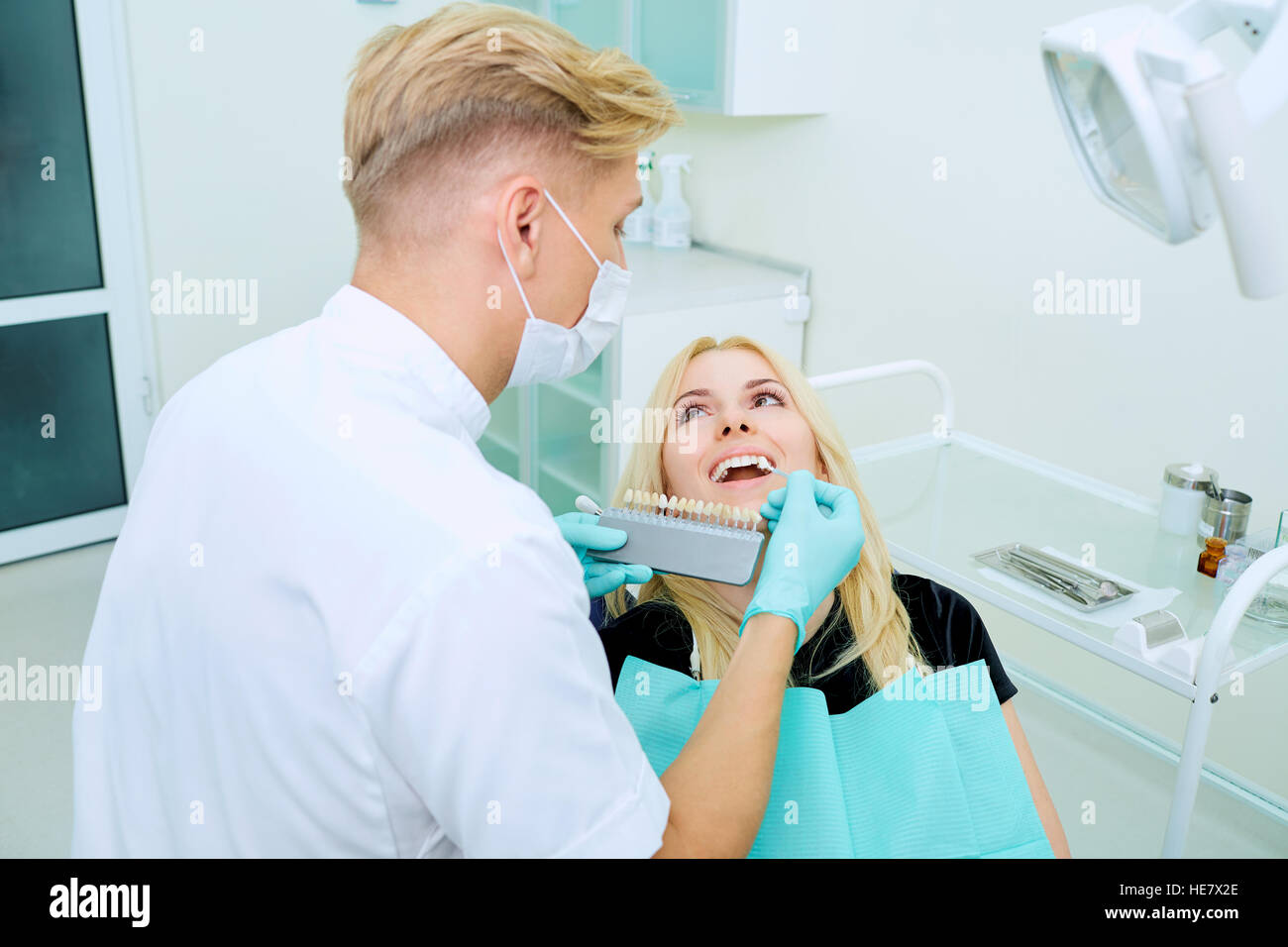 Dentista tenta di scegliere il colore dei denti e client Foto Stock