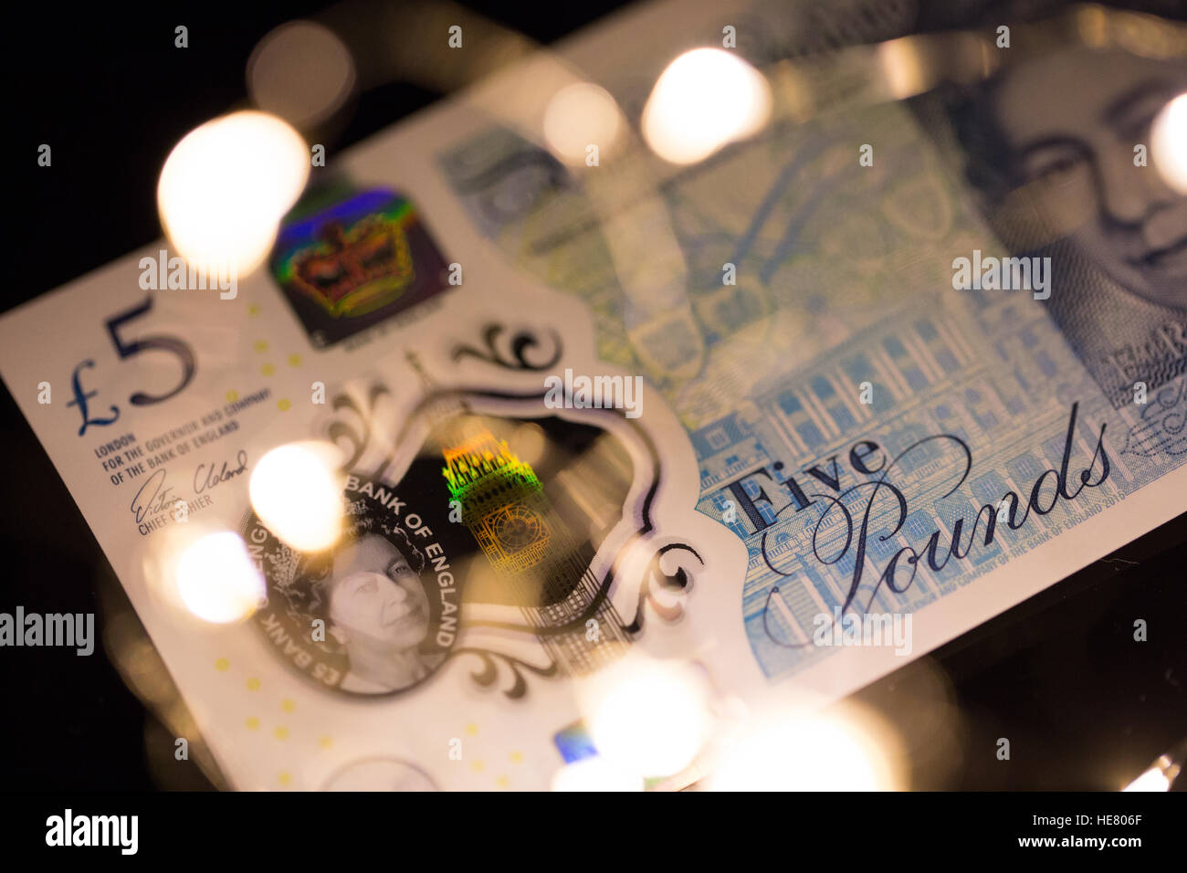 Close up del nuovo polimero 2016 cinque pound nota con luci sfocate in primo piano. Foto Stock