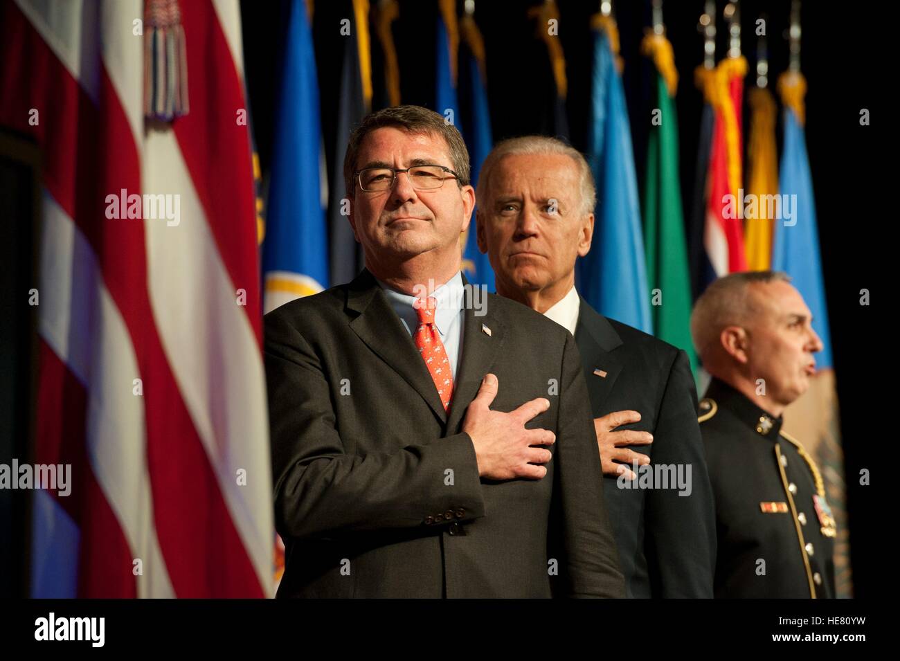 Stati Uniti Vice presidente Joe Biden e il Segretario della Difesa Ashton Carter stand per l'Inno Nazionale durante una cerimonia di transizione per miniera agguato resistente veicoli protetti al Pentagono Ottobre 1, 2012 a Washington, DC. La cerimonia segna la transizione del programma MRAP dal Marine Corps all'esercito. Foto Stock