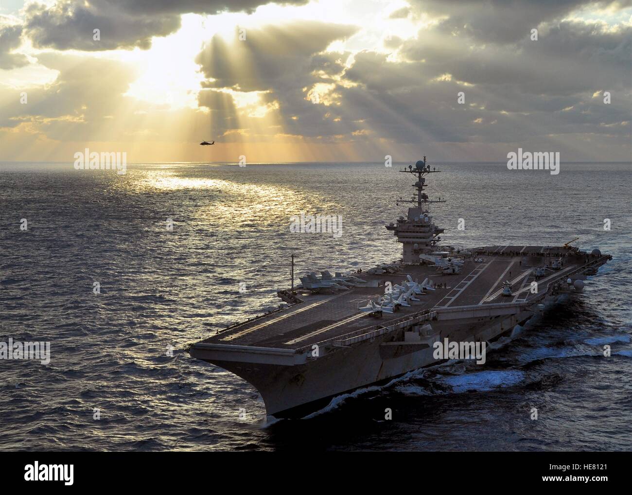 Un Sikorsky SH-60B Seahawk elicottero vola a fianco della USN Nimitz-class portaerei USS George Washington nel loro passaggio al tramonto Novembre 18, 2009 nell'Oceano Pacifico. Foto Stock