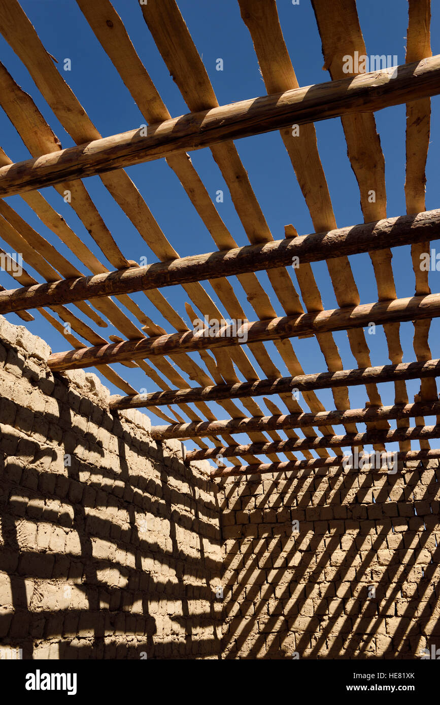 Ombre diagonali di travi a soffitto e spranghe su pareti in mattoni di fango di una casa incompiuta vicino a Shymkent Kazakistan Foto Stock
