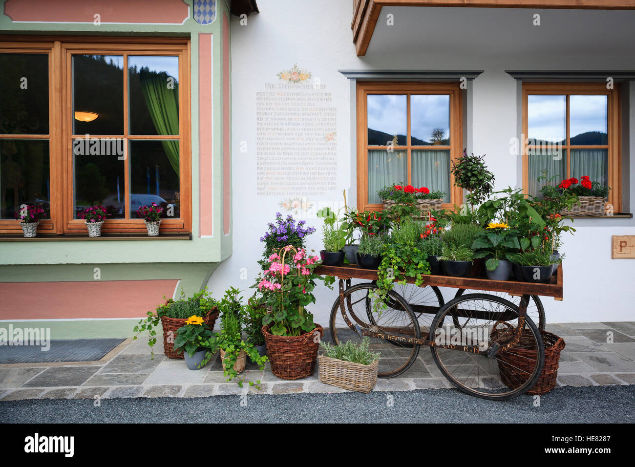 Un vecchio carro di legno decorate con fiori. Hotel Gut Steinbach. Reit im Winkl. Alta Baviera. Germania. Foto Stock