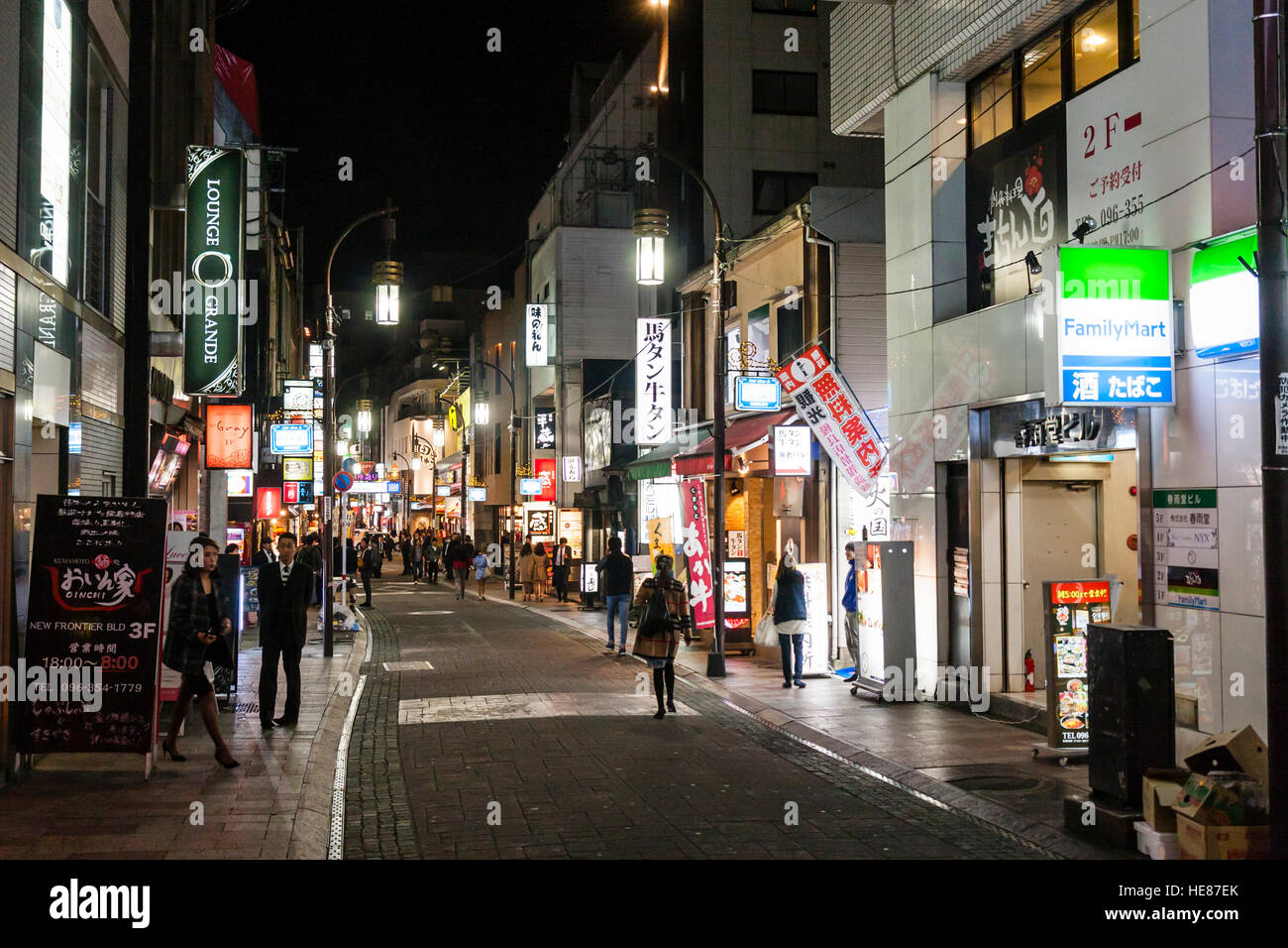 Giappone Kumamoto, Shimotori Arcade Street. Lato strada piena di ristoranti e club. La famiglia smart sign in primo piano. Notte tempo. Foto Stock