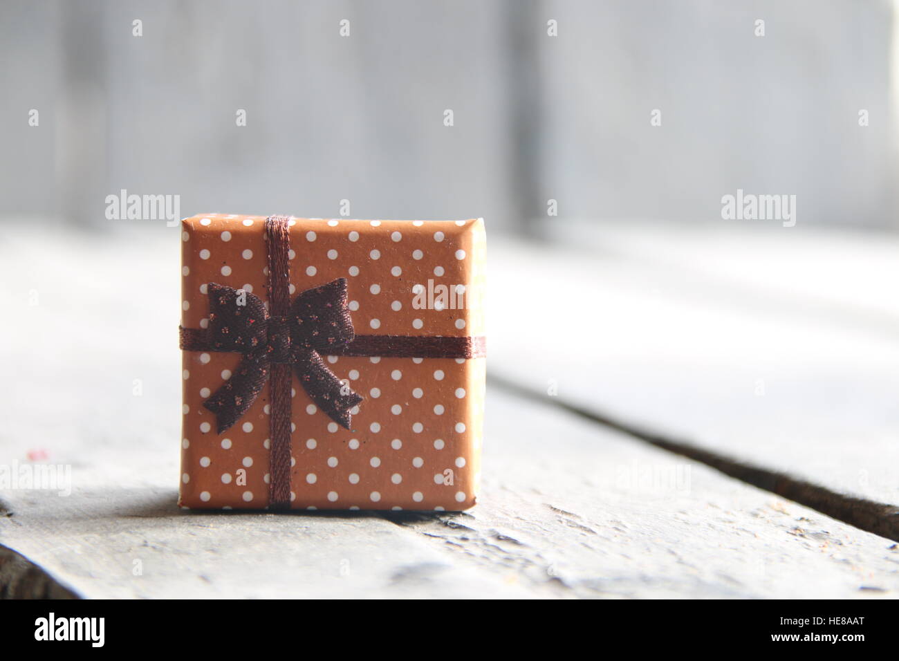 Confezione regalo con nastro sul tavolo di legno, sullo sfondo di Natale Foto Stock