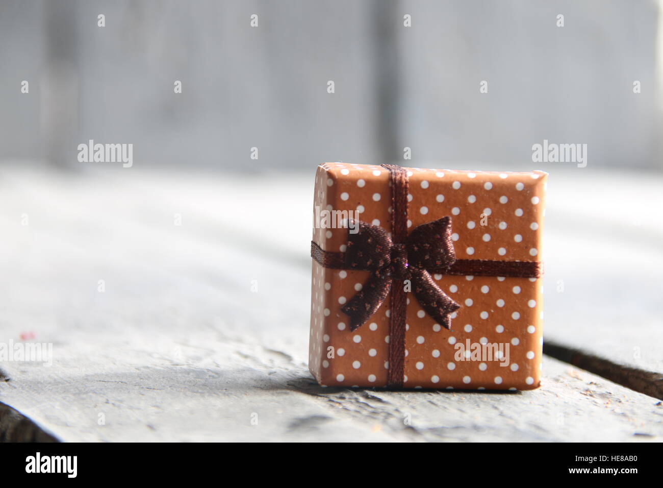 Confezione regalo con nastro sul tavolo di legno, sullo sfondo di Natale Foto Stock