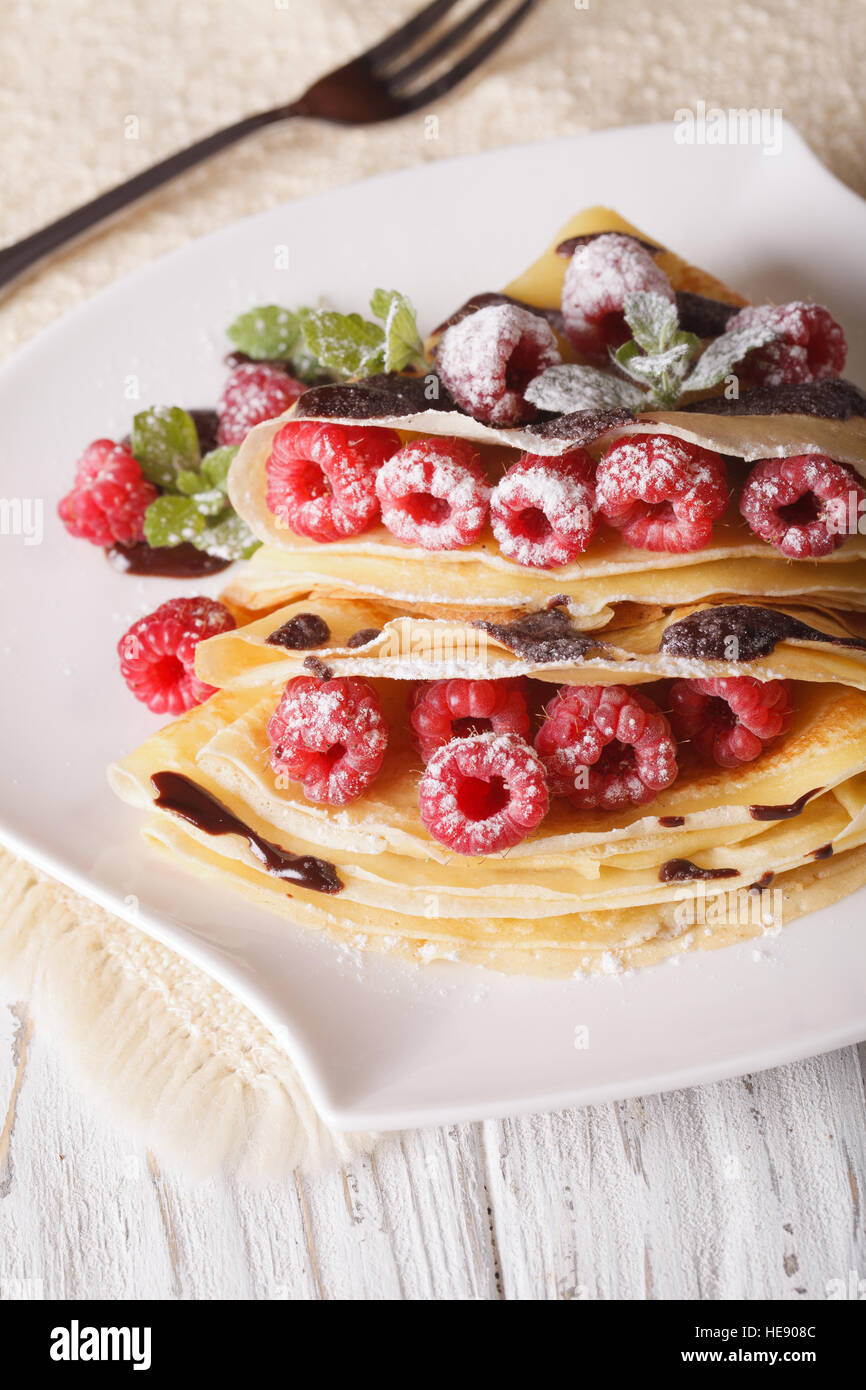 Bella lampone crepes con cioccolato close-up su una piastra verticale. Foto Stock