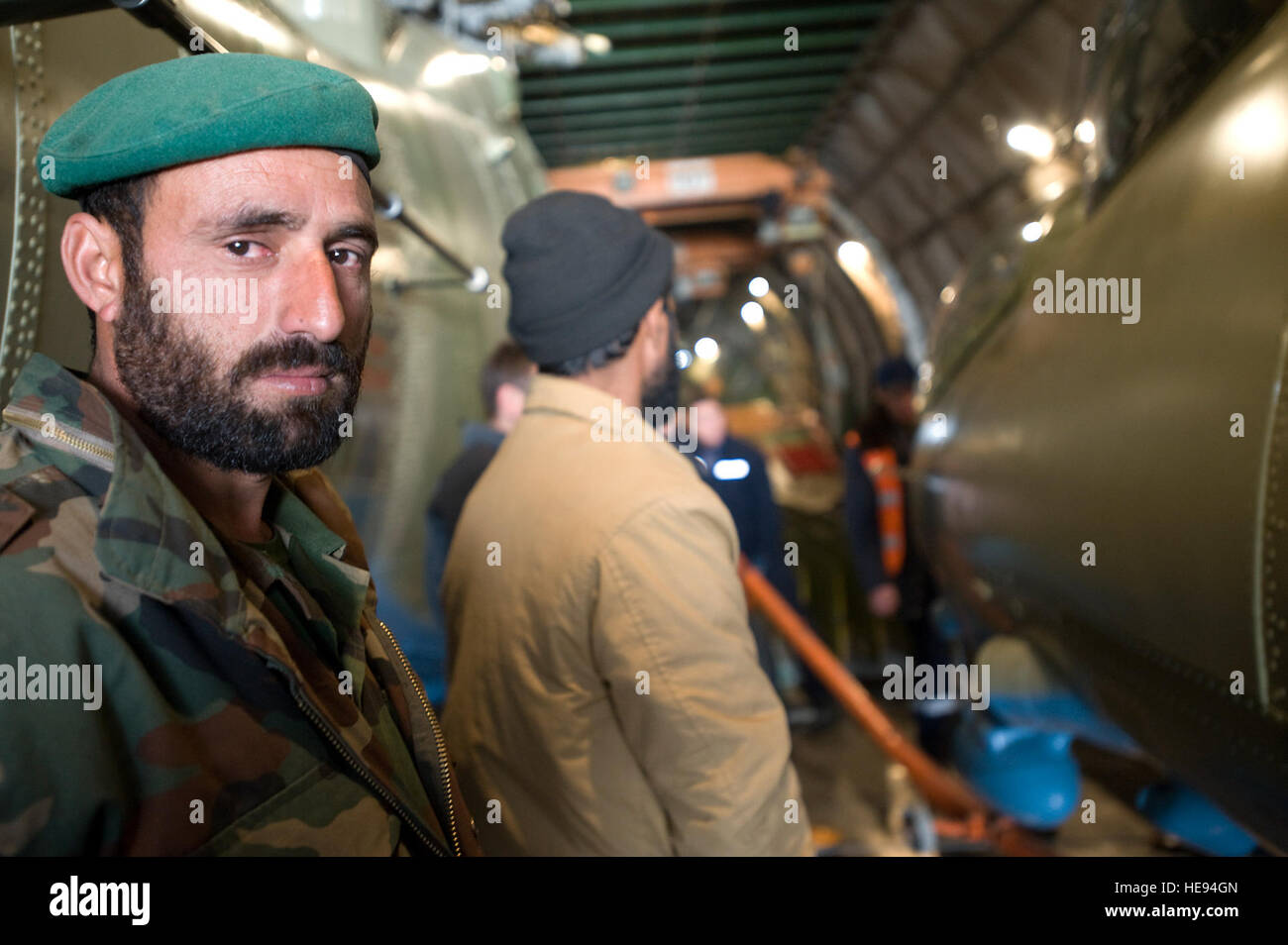 Un esercito nazionale afghano air corps airman attende per aiutare a scarico parti per tre ristrutturato di recente Mi-17 di elicotteri che sono arrivati qui su un AH-124 piano di trasporto. Il ANAAC viene supervisionato su tutti gli aspetti delle operazioni di volo da aviatore dal 438th Air Expeditionary ala. Foto Stock