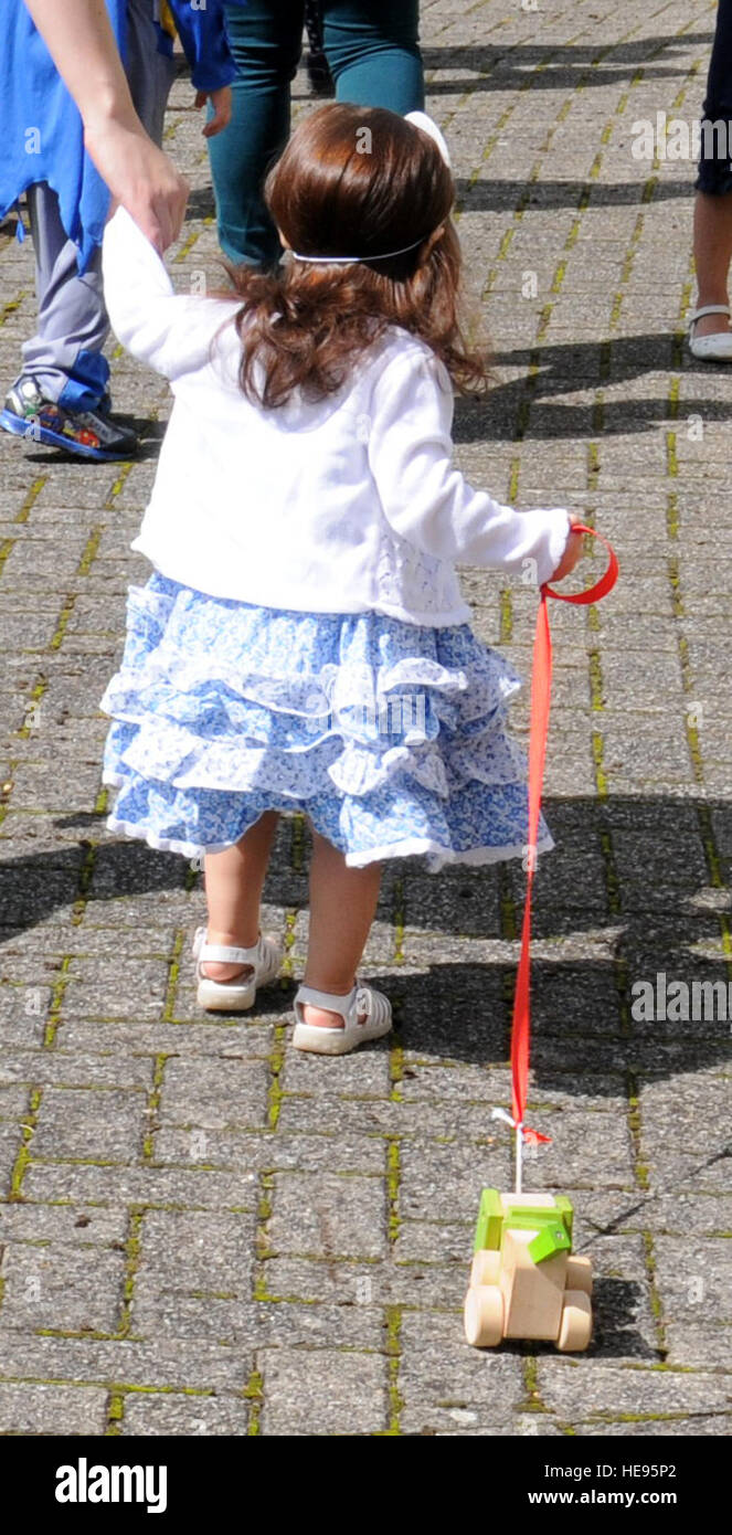 Un Team Mildenhall bambino prende parte a una "zampe di leggere " parata del pet e del costume contest Agosto 13, 2014, presso la libreria sulla RAF Mildenhall, Inghilterra. La ragazza camminava il suo modello proprio cane durante la sfilata e gli organizzatori ha incoraggiato tutti gli ospiti di portare un animale vero o un peluche per la parata. Gina Randall Foto Stock