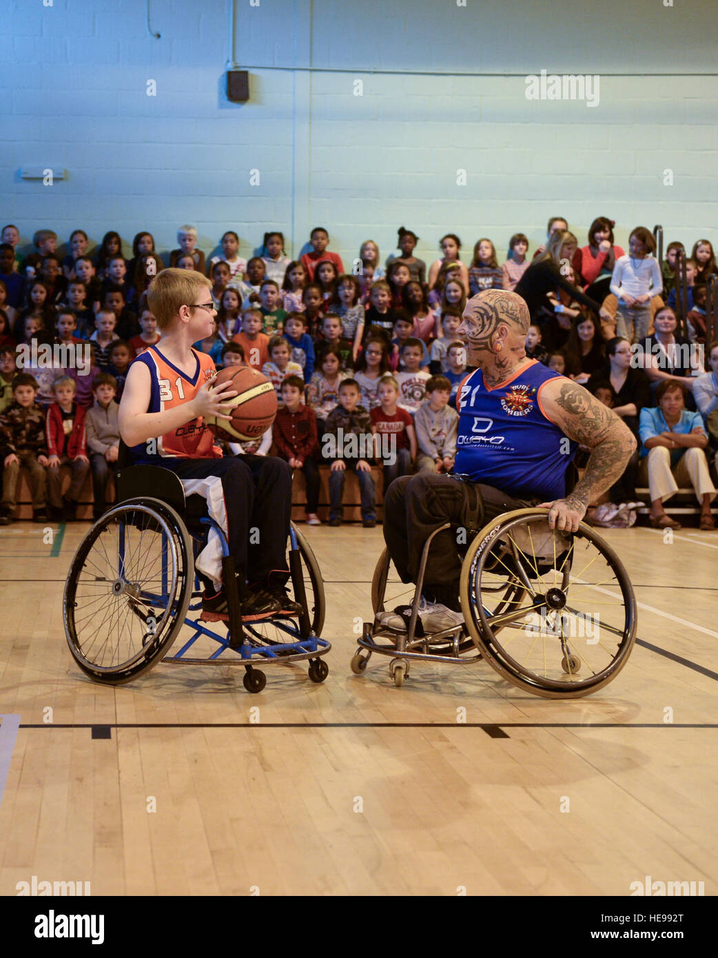 Oliver Guest (sinistra) OFF volti contro il suo padre Paolo ospite durante i bombardieri Bury exhibition match nella Royal Air Force Lakenheath, Inghilterra, il 22 ottobre, 2013. Durante i bombardieri' visita i bambini acquisiscono conoscenze nello sport del basket in carrozzella mentre anche essere instillato con il rispetto delle persone con disabilità. Airman 1. Classe Nigel Sandridge Foto Stock