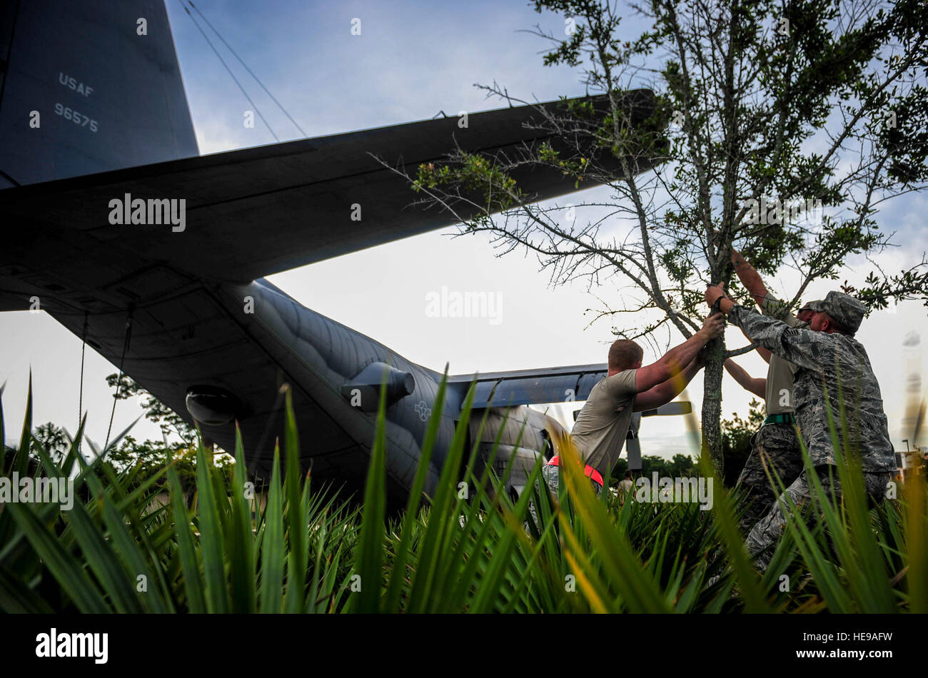 Avieri con il 1° di particolari operazioni di manutenzione di velivoli Squadron spostare un albero per evitare il contatto con la coda di un AC-130H spettro sul campo Hurlburt Fla., 15 agosto 2015. Più di 40 personale da otto organizzazioni di base sono state sul sito durante il processo di traino. L'AC-130H sarà visualizzato all'estremità del nord del parco dell'aria. Senior Airman Meagan Schutter) Foto Stock