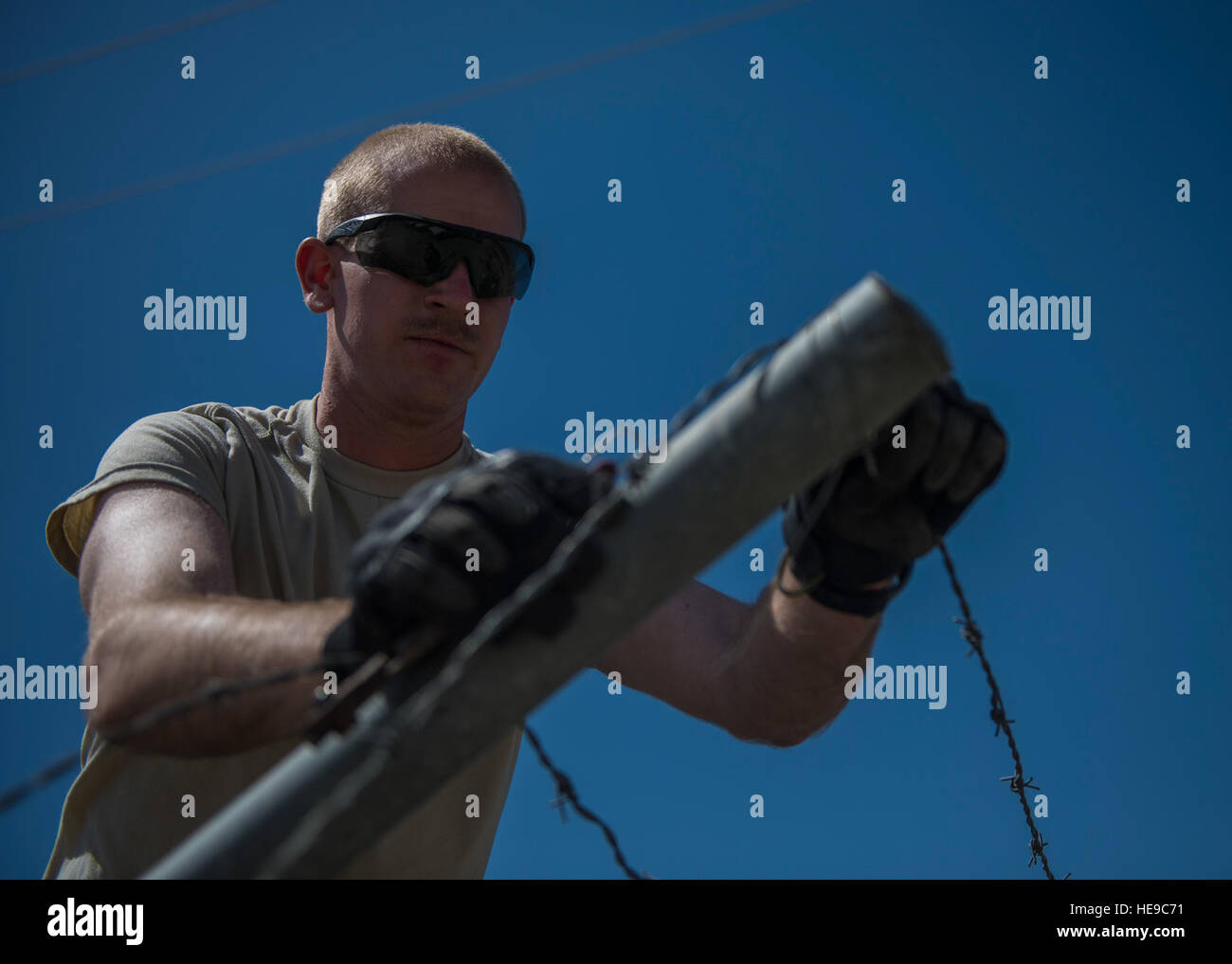 1Lt. Contrassegnare Bohme, 455th Expeditionary ingegnere civile squadrone tecnico di progetto, unclips barb filo da un palo da recinzione durante una demolizione, 22 giugno 2016, Bagram Airfield, Afghanistan. Gli ingegneri di sviluppo pianificare, organizzare e implementare sistemi di ingegneria dei processi nonché di identificare e di incorporare nuove tecnologie. Senior Airman Justyn M. Freeman) Foto Stock