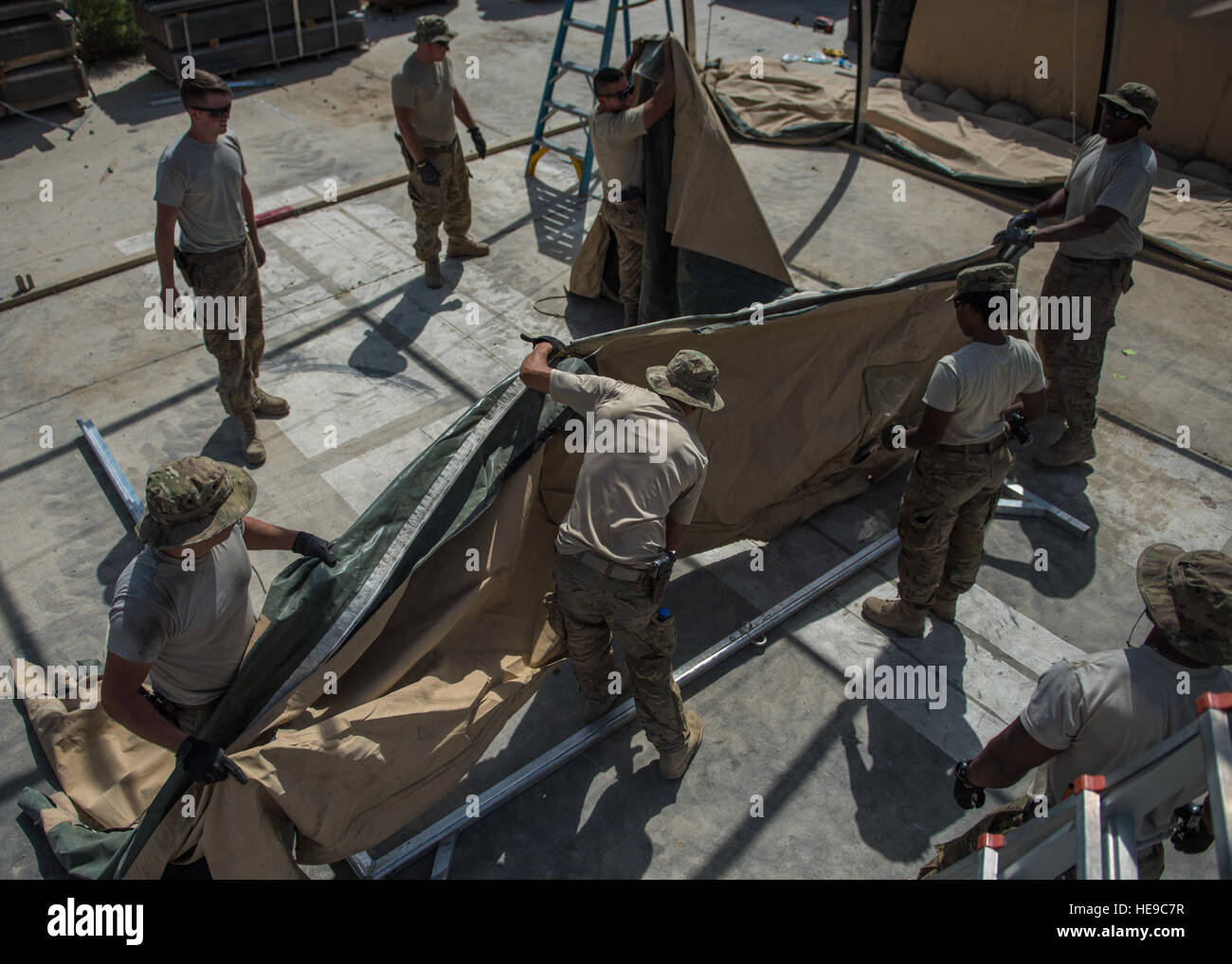 Airman dal 455th Expeditionary ingegnere civile Squadron lavorano insieme per mettere il tessuto su una tenda scheletro, Giugno 25, 2016, Bagram Airfield, Afghanistan. Tutti i voli entro il 455th ECES, comprese le strutture, sporcizia boys, e componenti elettrici sono venuti insieme per costruire una nuova tenda a spostare la produzione di energia e riscaldamento, ventilazione e aria condizionata negozi. Senior Airman Justyn M. Freeman) Foto Stock