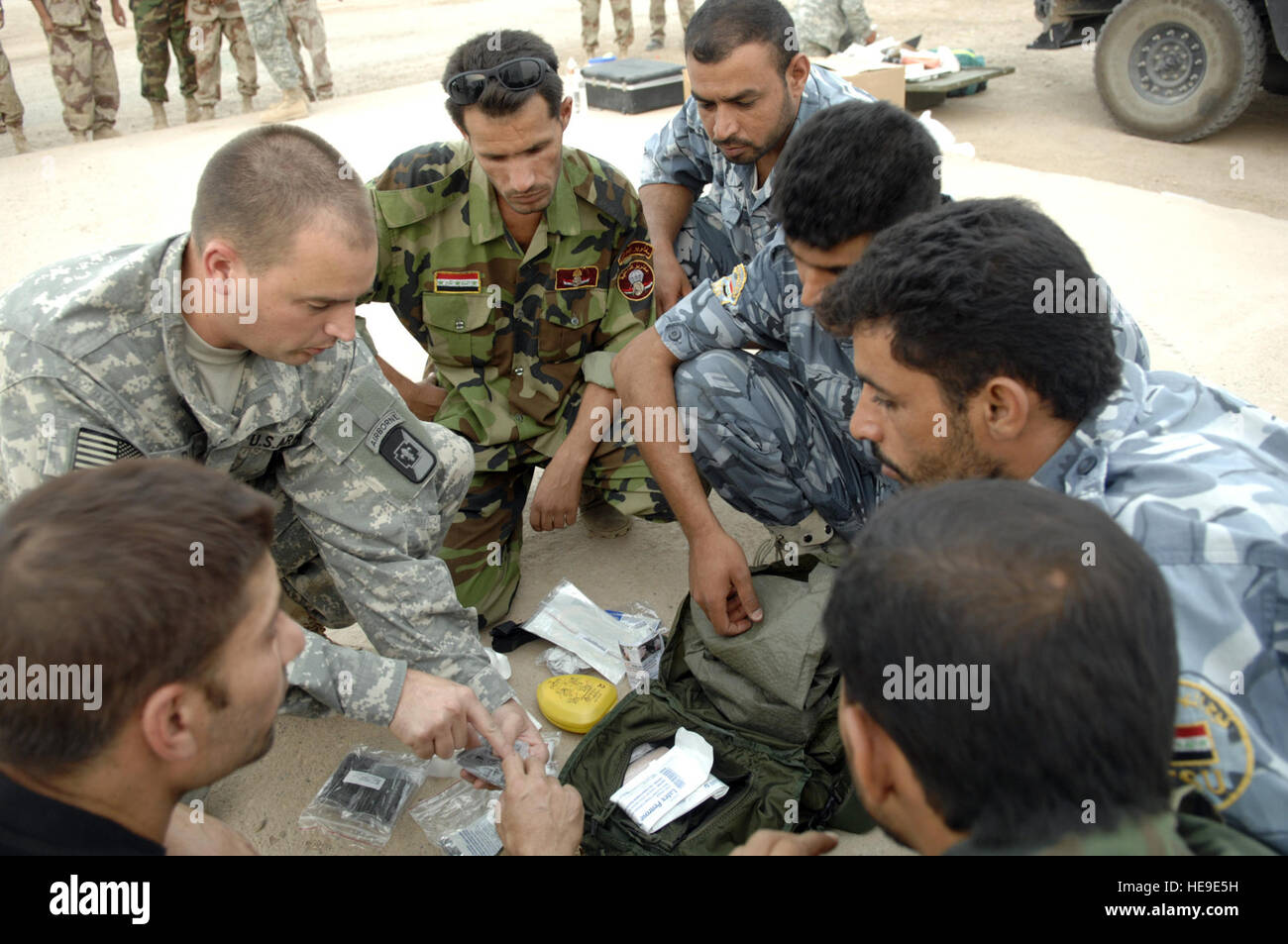 Spc. Keith Rudd, 250 in avanti il team chirurgico, 82d Airborne, Camp sommatore, Iraq, esamina il contenuto di un kit medico con poliziotti Iracheni durante un combattimento casualty corso di trattamento a Camp Mitica, Iraq, Sett. 10. I poliziotti iracheni di frequentare la formazione sono tutti membri dell'An Nasiriyah tattico di unità di supporto. Foto Stock