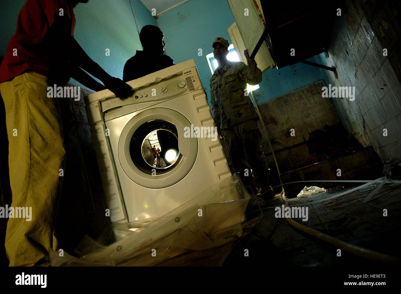 Con l aiuto di un abitante del Gibuti orfano, Builder 1. Classe Mark Gerth prepara l'installazione di una macchina di lavaggio come parte di una tre giorni di servizio comune di assistenza comunitaria volontari (CAV) progetto il 21 febbraio 2008, mentre dispiegato per la Combined Joint Task Force - Corno d'Africa si trova a Camp Lemonier, Gibuti. Il team di Cav attraverso donazioni e raccolte di fondi aiuta a ristrutturare un ragazzo in orfanotrofio/scuola così come la donazione di una macchina di lavaggio per l'orfanotrofio/scuola chiamato l'Assemblea Mondiale des Jeunes Musulmans Centre National pour la protezione. Tech. Sgt. Jeremy T. serratura) Foto Stock