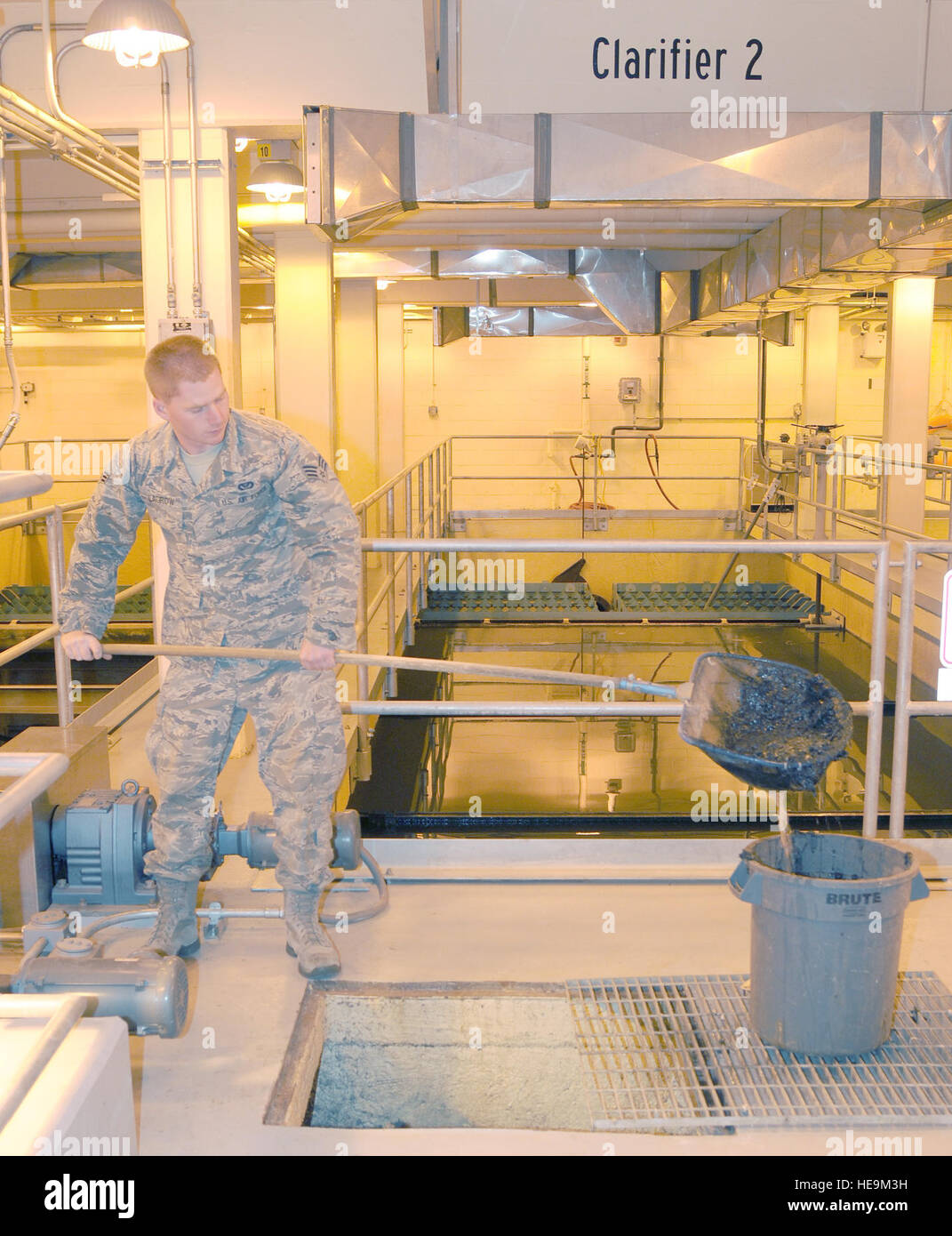 Stati Uniti Air Force Senior Airman Giuseppe Lagrow, 354Ingegnere Civile Squadron impianto di trattamento delle acque reflue operatore, scoop lo strato superiore di fanghi fuori da una scatola di distribuzione Giugno 1, 2012, Eielson Air Force Base in Alaska. Le caselle sono cancellati ogni giorno per garantire che essi distribuiscono uniformemente il flusso in chiarificatori. Senior Airman Janine Thibault) Foto Stock