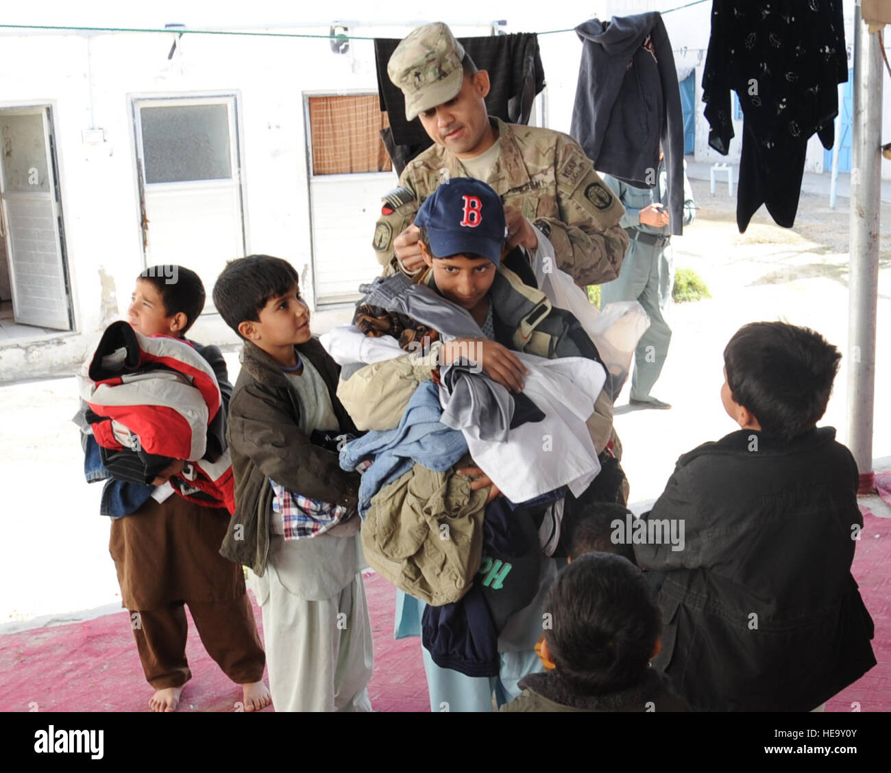 Provincia di Kandahar, Afghanistan -- STATI UNITI Il cappellano dell'esercito (Capt.) Antonio Garcia-Mendez, 385 Polizia Militare Battaglione Cappellano distribuito da Ft. Stewart, Ga., mani cappelli per bambini durante una visita alle donne e ai bambini la sezione della prigione di Sarposa Dic. 3. L'innesto femmina Team e membri di Camp Nathan Smith raccolti articoli di abbigliamento e articoli di igiene di passare fuori per le donne e i bambini. Senior Airman Sean Martin, Kandahar Provincial Reconstruction Team) (rilasciato) Foto Stock