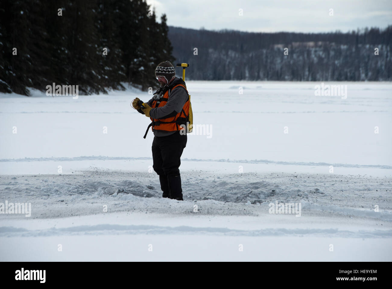 Arte Gelvin, un tecnico di ingegneria con le regioni fredde Ricerca e laboratorio di Ingegneria di Hannover, N.H., sorge nel cratere di detonato mortaio in giro per il fiume Eagle appartamenti, Feb 19, 2013. Gelvin è la raccolta di un segnale GPS per individuare la posizione della detonazione. (Air Force Photo/ Airman 1. Classe Omari Bernard) Foto Stock