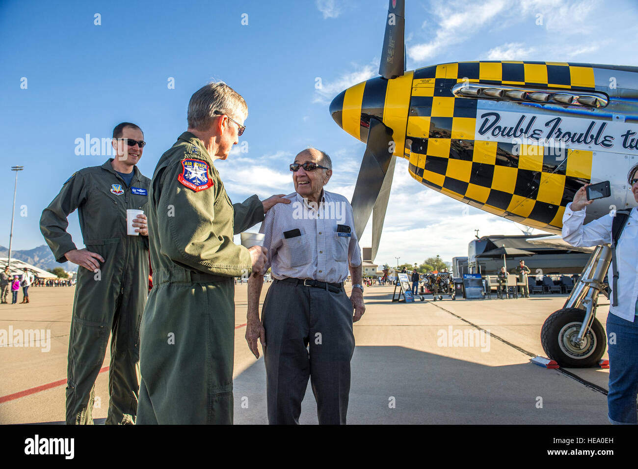 Col. James Meger, Comandante della 355Fighter Wing, orologi come gen. Herbert J. 'Hawk' Carlisle, Commander, Air Combat Command, Langley Air Force Base, Virginia, chat con Fred Roberts, 93, un ex P-51D pilota con 354Fighter Squadron, 355Fighter Group in Inghilterra durante la seconda guerra mondiale. I piloti ha parlato su la linea di volo mentre era aperto al pubblico prima che i voli di allenamento ha cominciato a Patrimonio Flight Training Course a Davis-Monthan AFB, Tucson, Arizona, Mar 5, 2016. J.M. Eddins Jr.) Foto Stock