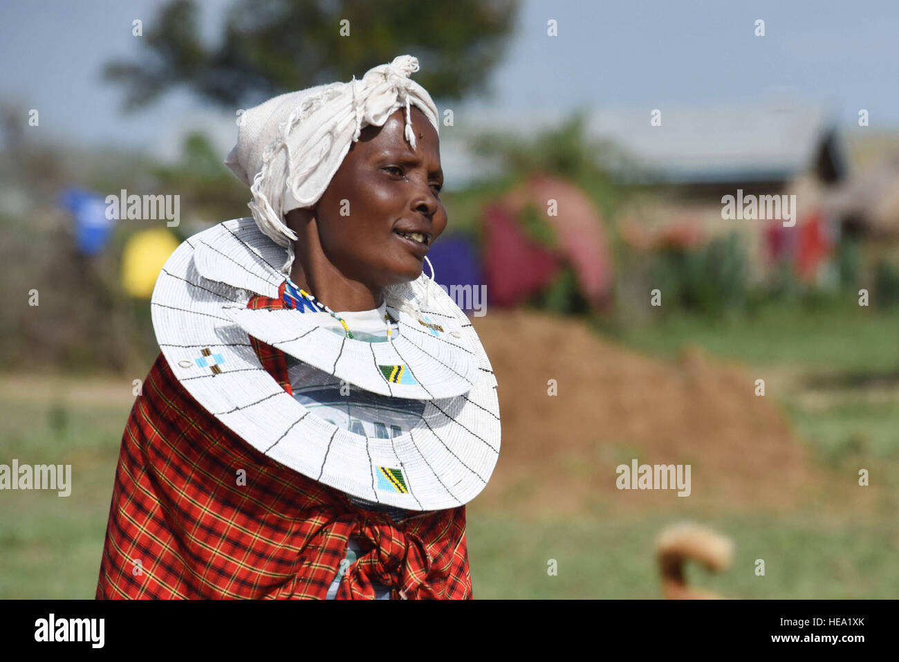 Una donna Maasai mostra abiti tradizionali e decorazioni del collo durante una visita culturale in Tanzania, mettendo in evidenza le usanze locali, la storia e gli aspetti unici della cultura Maasai durante un seminario di integrazione di genere. Foto Stock